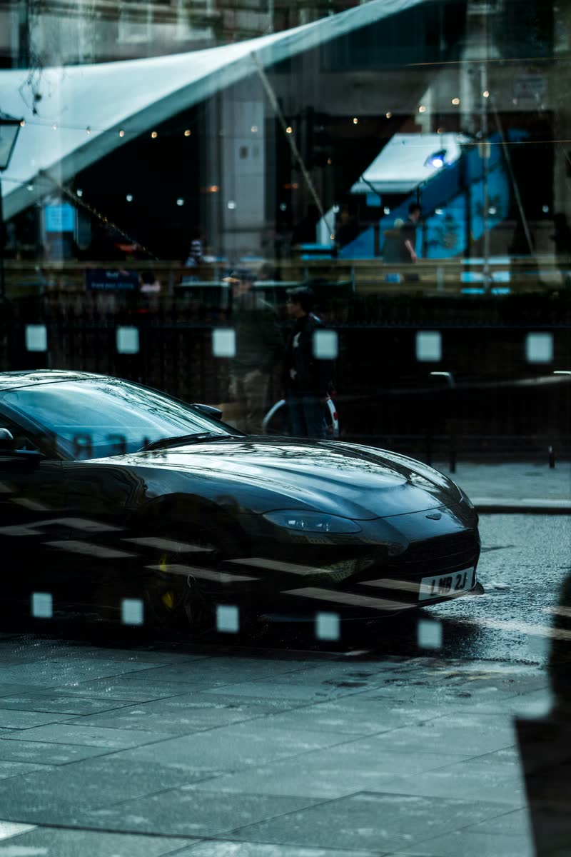 Spiegelung eines Sportwagens in einer Glasfront